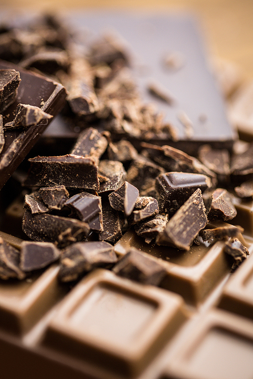 Close up view of dark and milk chocolate on a wooden table