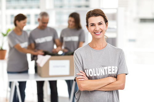 Portrait of smiling female volunteer with arms crossed in the office
