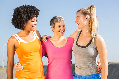 Sporty women smiling at each other at promenade