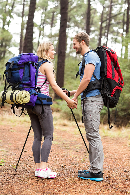 Young happy hiker couple looking at each other in the nature