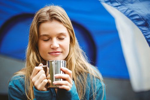 Portrait of a young pretty hiker sitting in a tent in the nature