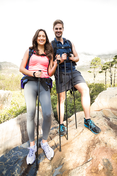 Young happy joggers standing on rock in the nature