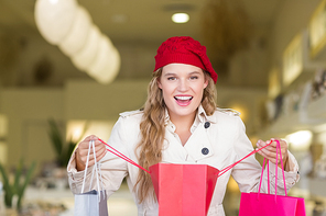 A happy smiling woman looking into a bag at the mall