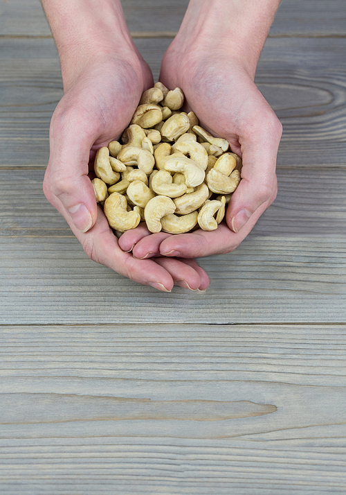 Woman showing handful of cashews in close up