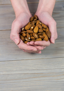 Woman showing handful of almonds in close up