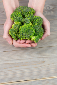 Woman showing fresh green brocolli in close up