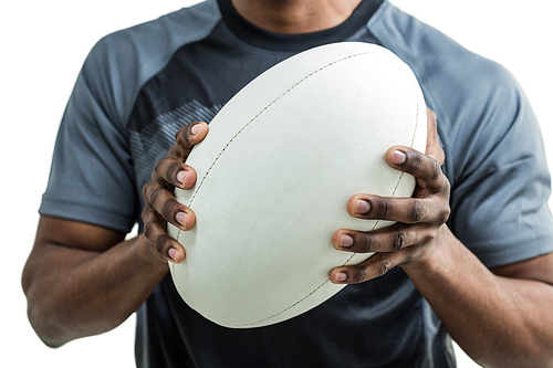 Mid section of sportsman holding rugby ball against white background