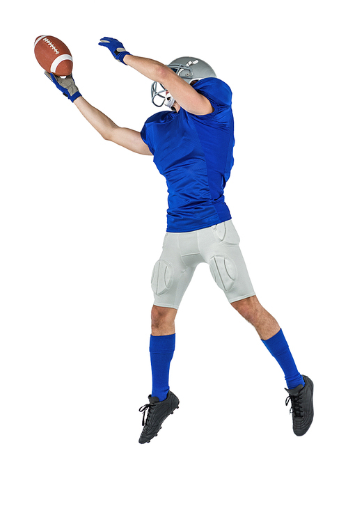 Full length of sports player catching ball in mid-air against white background