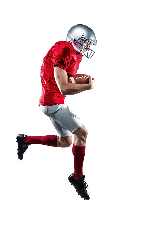Full length of American football player holding ball while running against white background