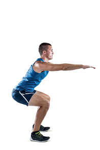 Full length of fit man doing squats on white background