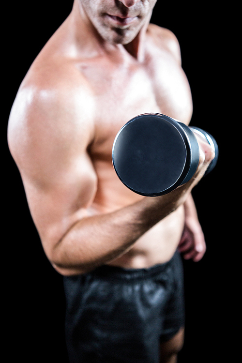 유토이미지 | Midsection of shirtless man working out with dumbbell against black background