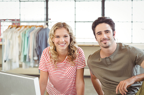 Portrait of smiling fashion designers in creative office