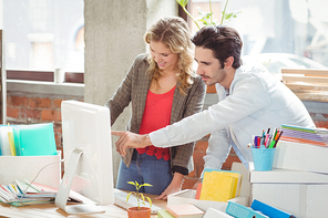 Businessman pointing towards computer in creative office