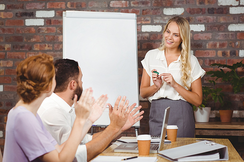 Colleagues applauding businesswoman during presentaion