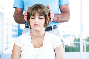 Close-up of male therapist performing reiki over woman at health club