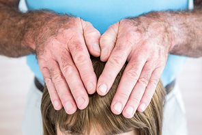 Close-up of male hands performing reiki over woman at health center