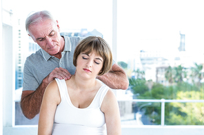 Therapist massaging pregnant woman at health club