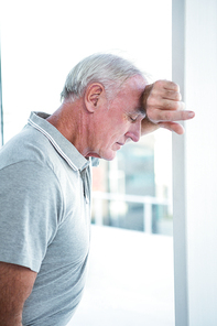 Depressed mature man leaning on wall at home