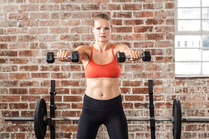 Fit woman exercising with dumbbell