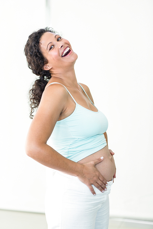 Happy pregnant woman touching her belly