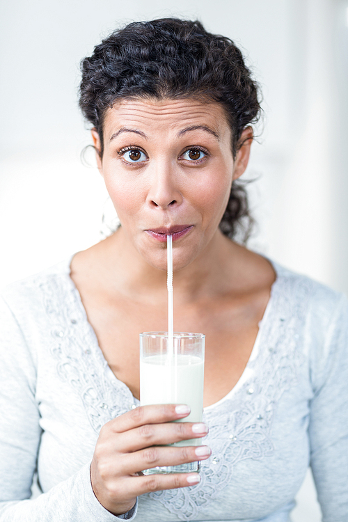 Beautiful pregnant woman drinking a glass of milk