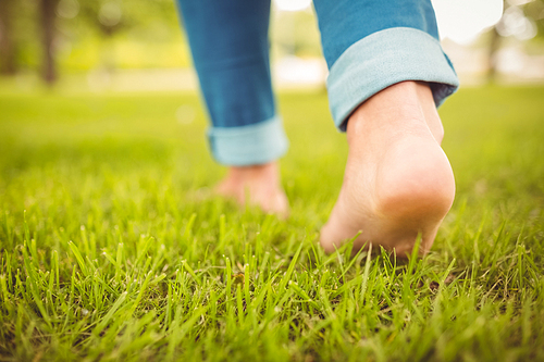 Low section of woman walking on grass