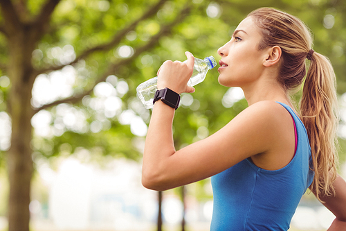 Jogger woman drinking water in park