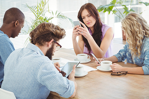 Business professionals using technology while sitting at desk