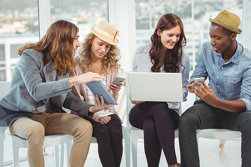 Business people using technology while discussing