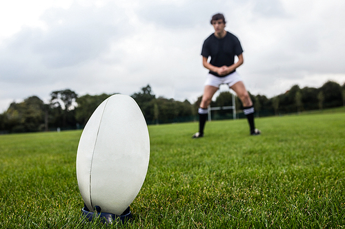 Rugby player about to kick ball