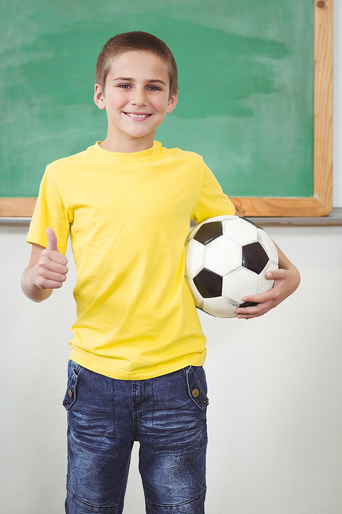 유토이미지 | Portrait of smiling pupil holding football in a classroom in school