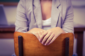 Teacher sitting on chair in a classroom in school