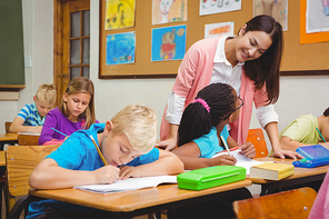 Smiling teacher helping a student at the elementary school