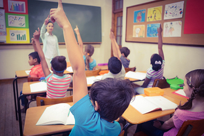 Pupils raising their hands during class at the elementary school