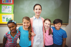 Teacher and pupils smiling in classroom at the elementary school