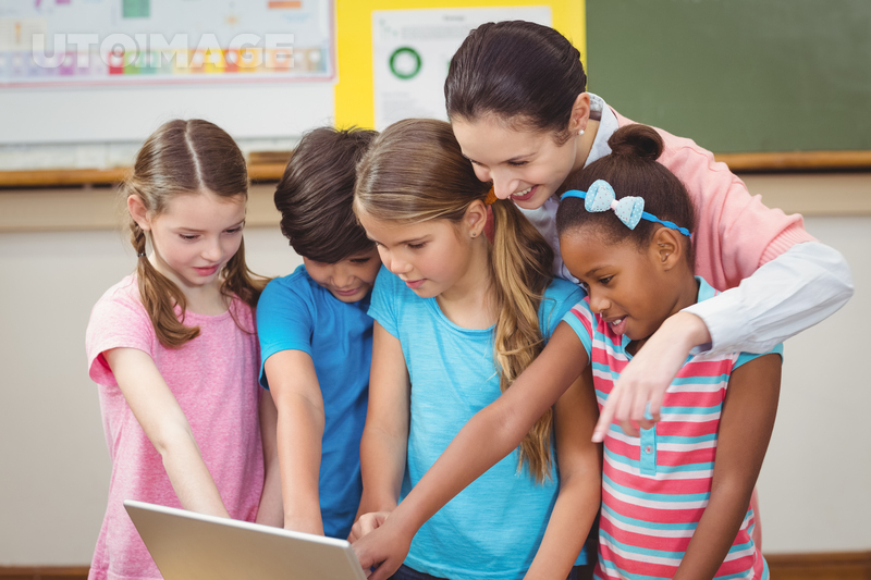 유토이미지 | Teacher and pupils looking at laptop at the elementary school