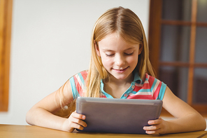 Cute pupil in class using tablet pc at the elementary school