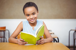 Smiling student reading a book at the elementary school