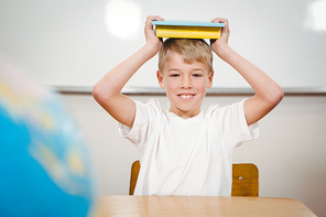 Pupil holding book over his head at the elementary school