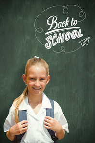 Cute pupil smiling at camera by the school bus against green chalkboard