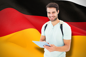 Student using tablet pc against digitally generated german national flag