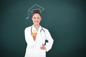 Smiling doctor offering an apple against teal