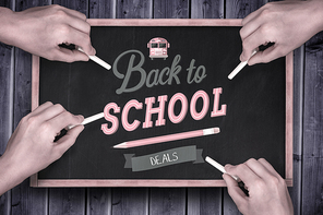 Multiple hands writing with chalk against blackboard with copy space on wooden board