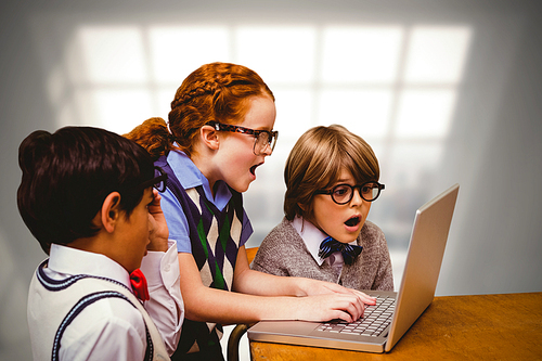 Pupils using laptop against room with large window showing city