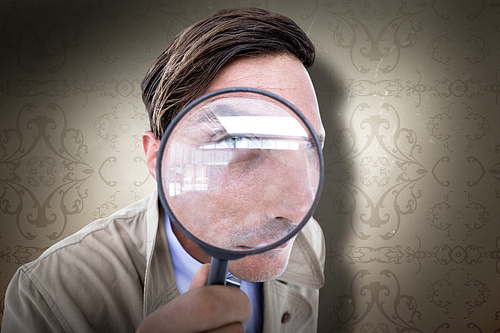 Spy looking through magnifier against elegant patterned wallpaper in neutral tones