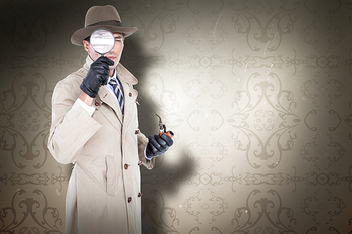 Spy looking through magnifier against elegant patterned wallpaper in neutral tones