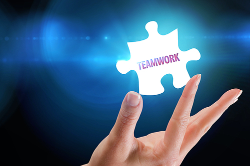 The word teamwork and hand showing against blue background with vignette