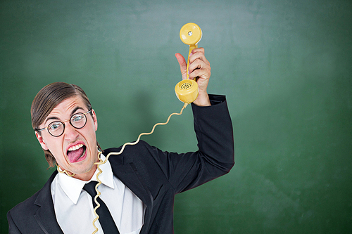 Geeky businessman being strangled by phone cord  against green chalkboard