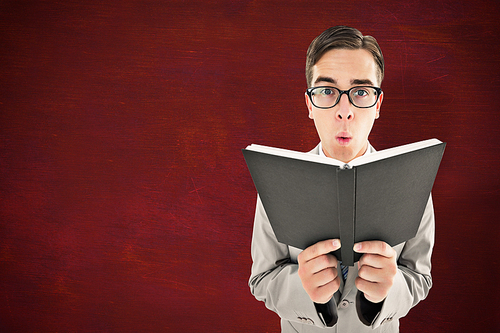 Geeky preacher reading from black bible against desk