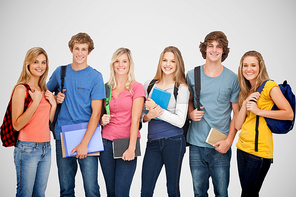 Smiling students all geared up for college against grey vignette